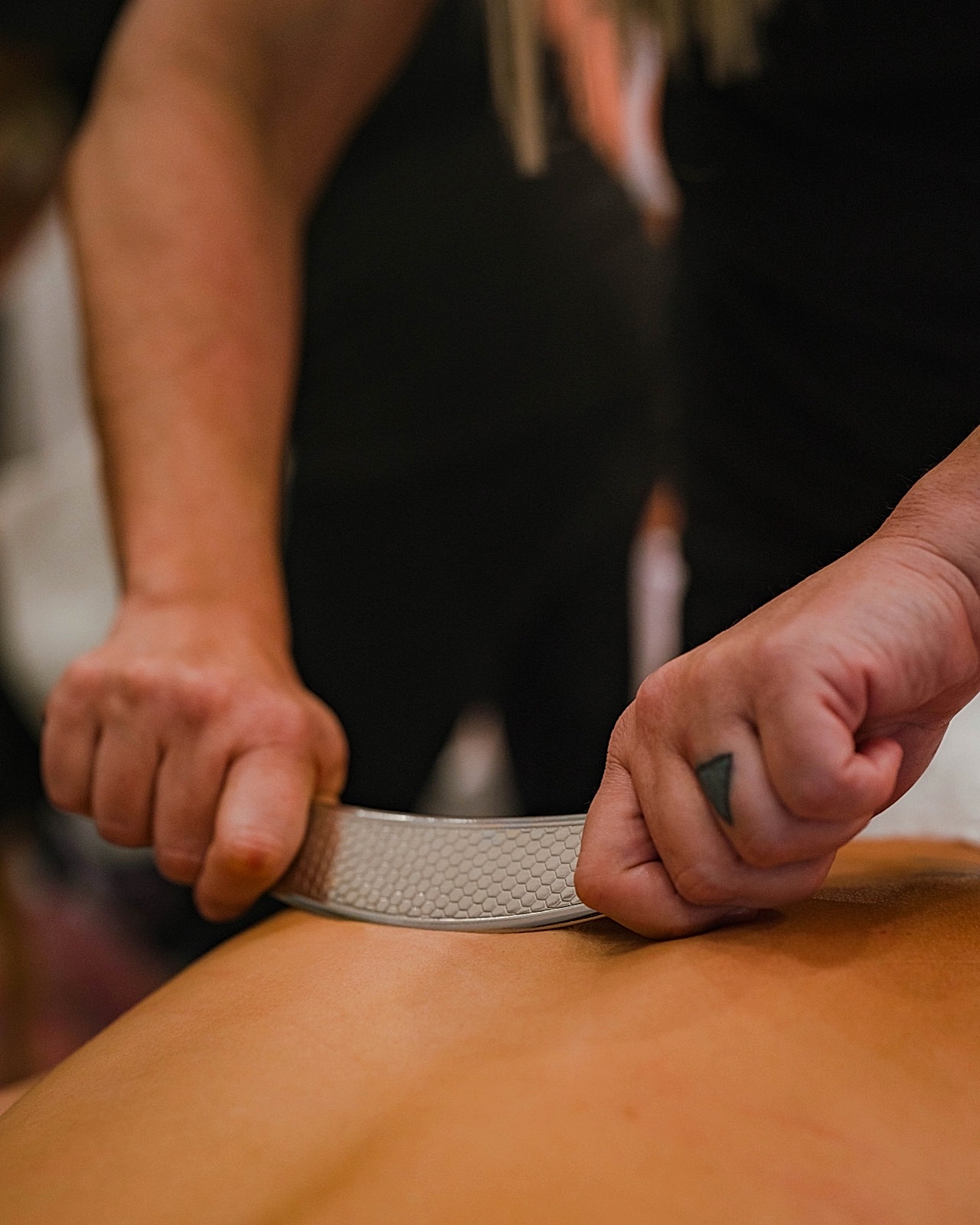 Scraping therapy on a client's back at Flex Fitness